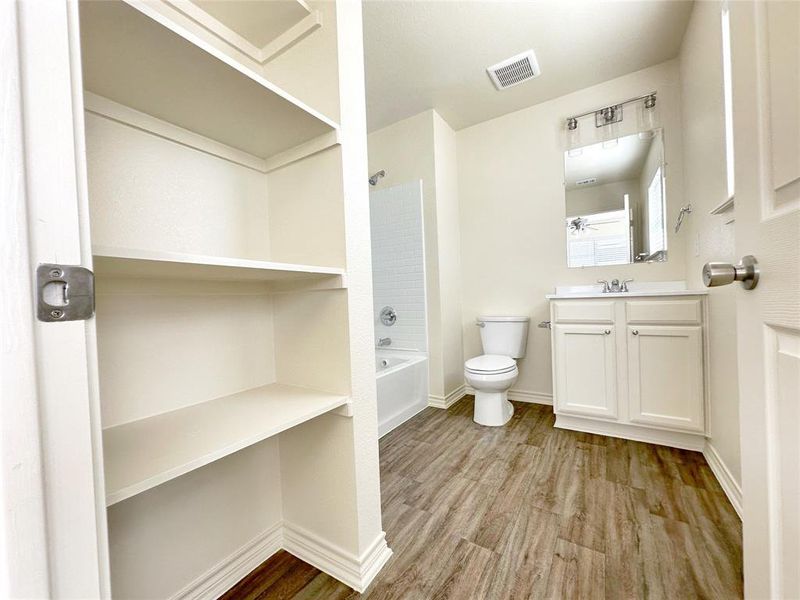 Bathroom with vanity, wood finished floors, and tub / shower combination