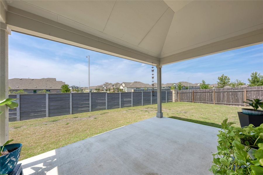 A spacious covered patio extends to a well-maintained yard, perfect for outdoor enjoyment.