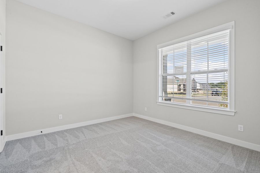 Empty room featuring baseboards and light colored carpet