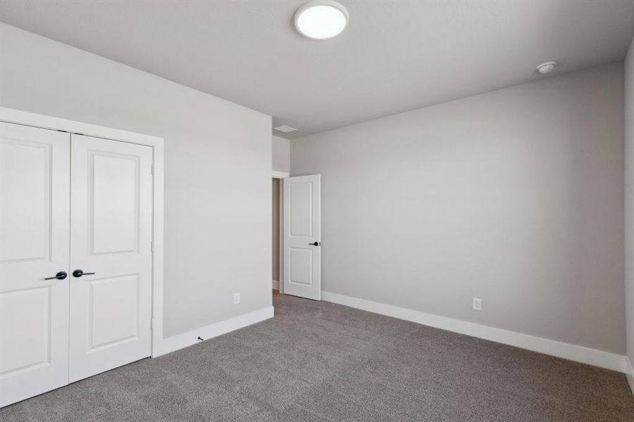 Unfurnished bedroom featuring carpet, baseboards, and a closet