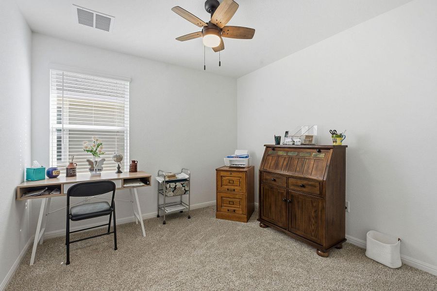 Home office featuring light carpet and ceiling fan