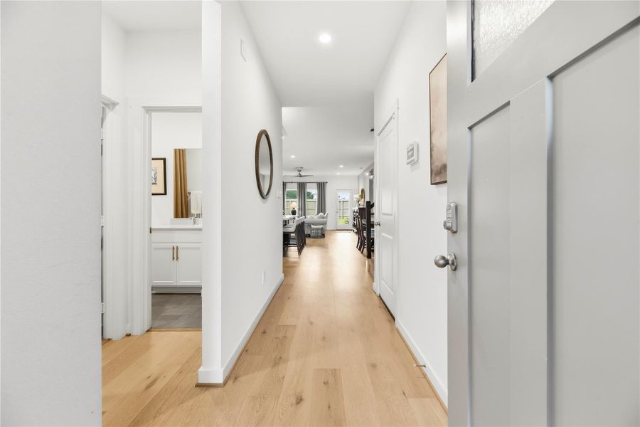 Entry foyer with hardwood flooring leading past the downstairs secondary bedroom to the main living area.