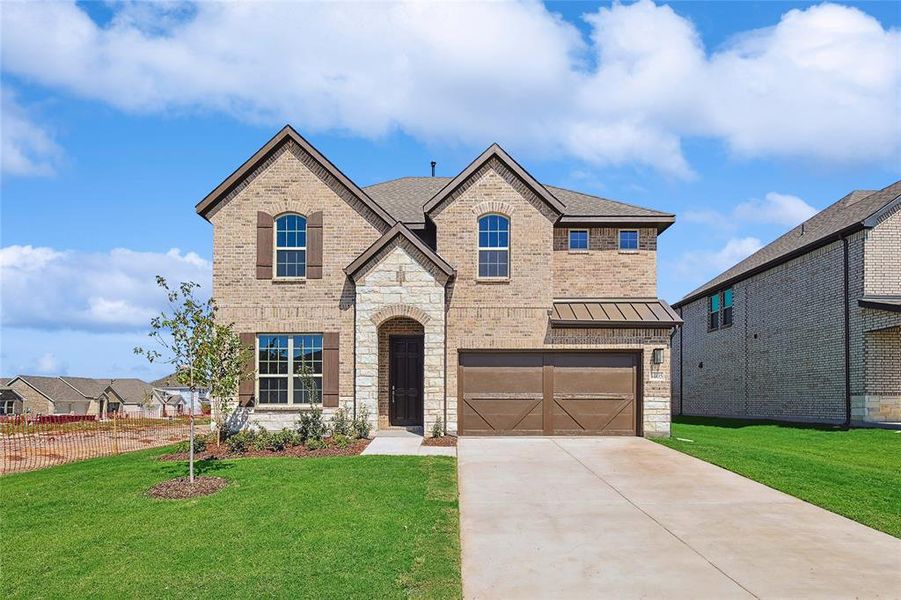 View of front of house with a garage and a front yard