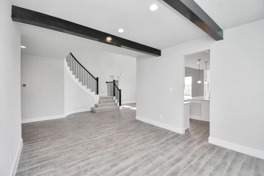 Create lasting memories with your family and friends at the dining table! This expansive dining room showcases sophisticated flooring, custom paint, and seamlessly connects to the family room and kitchen, providing an open and inviting atmosphere. Sample photo of completed home with similar floor plan. Actual colors and selections may vary.
