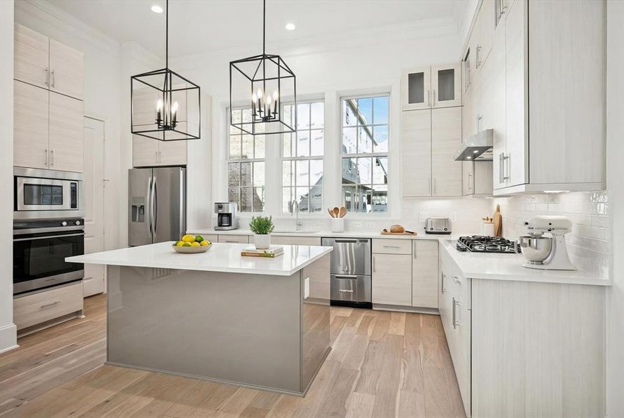 Modern kitchen featuring light wood-finish cabinetry, stainless steel appliances, a center island with a light countertop, and wood-finish flooring Modern kitchen featuring light wood-finish cabinetry, stainless steel appliances, a center island with a light countertop, and wood-finish flooring