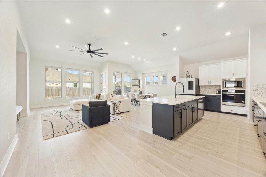 Natural light filled kitchen open to living and dining space.