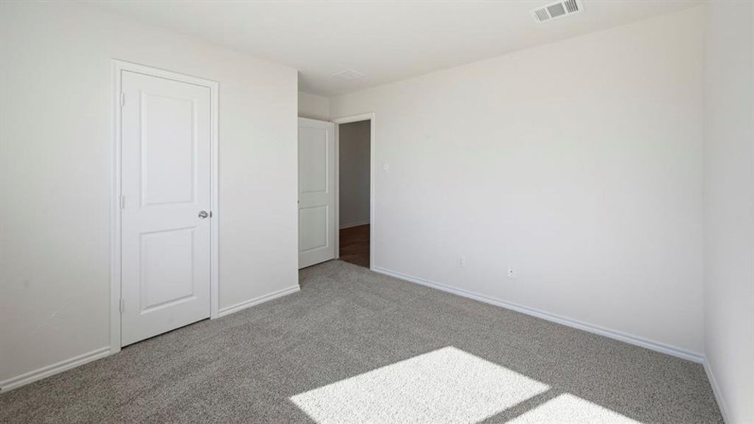 Unfurnished bedroom with carpet flooring and baseboards