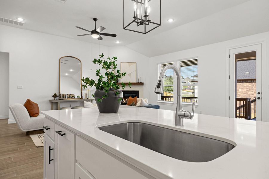 Kitchen with light stone countertops, white cabinetry, recessed lighting, open floor plan, and vaulted ceiling