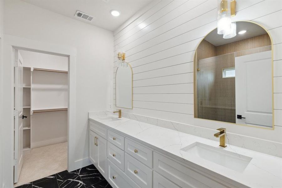 Full bathroom with double vanity, a sink, a walk in shower, and visible vents