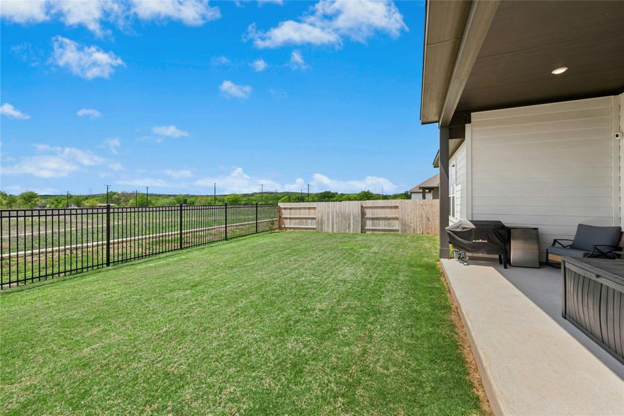 Large Fenced backyard featuring a patio