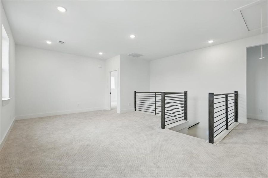 Empty room featuring attic access, carpet floors, recessed lighting, and baseboards