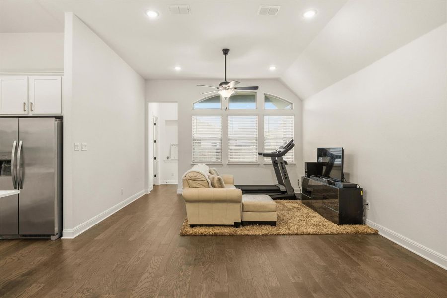Workout area featuring dark wood-style floors, vaulted ceiling, recessed lighting, and a ceiling fan