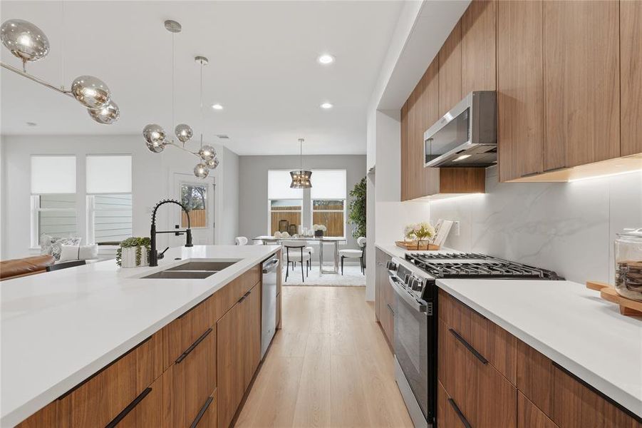 Kitchen featuring modern cabinets, wood finish cabinetry, stainless steel appliances, and light wood-type flooring Kitchen featuring modern cabinets, wood finish cabinetry, stainless steel appliances, and light wood-type flooring