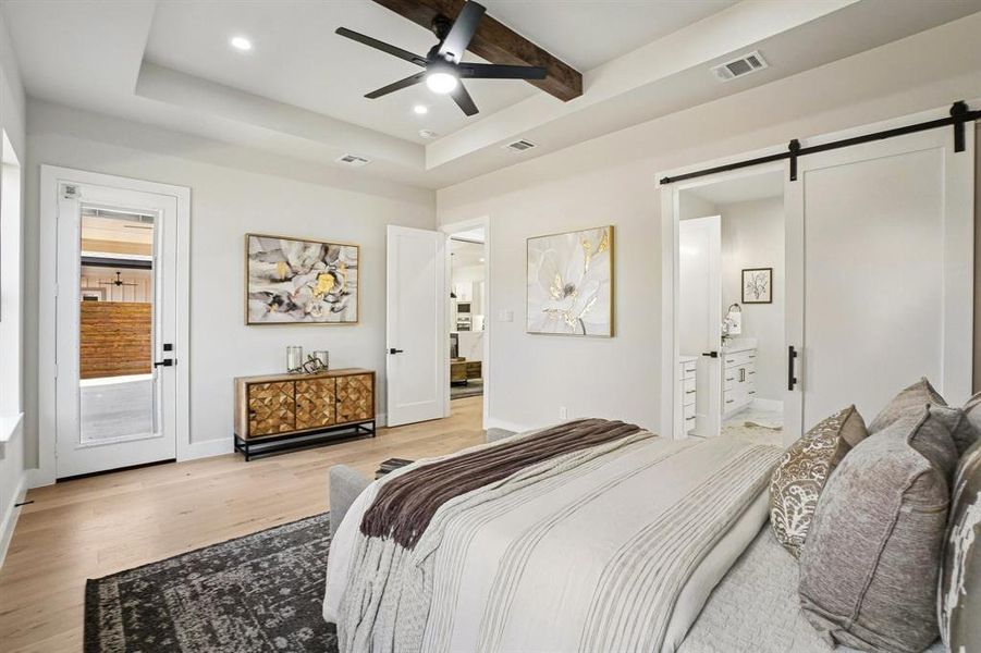 Bedroom with a barn door, light wood finished floors, ceiling fan, recessed lighting, and access to exterior