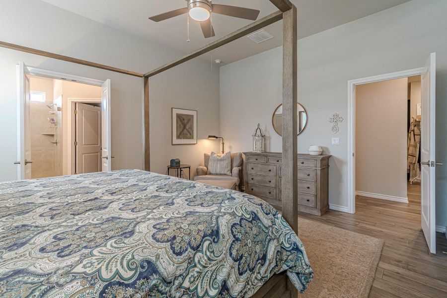 Bedroom with wood finished floors, lofted ceiling, baseboards, and a ceiling fan