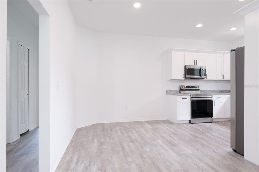 Dining room and kitchen entry view with open doorway to ball bedrooms