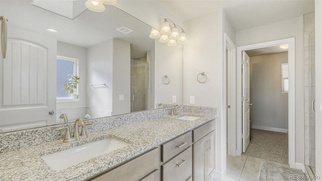double vanity in primary bathroom with walk-in closet