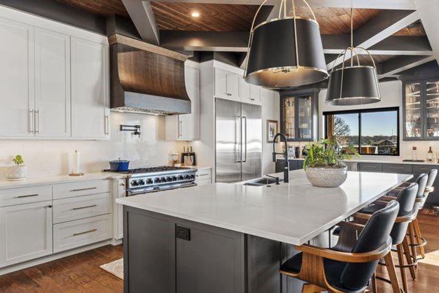Kitchen featuring a wooden ceiling with exposed beams, dark wood-type flooring, white cabinets, stainless steel appliances, and a large island