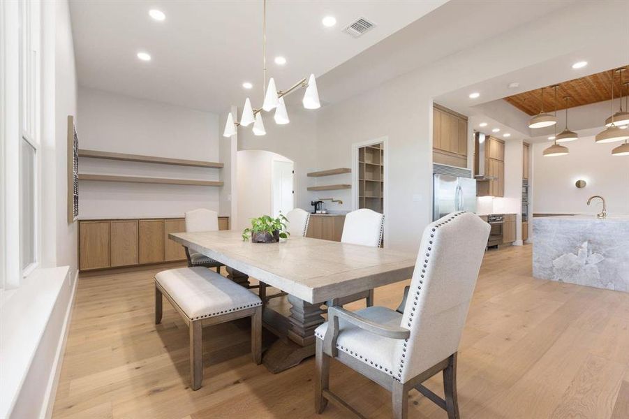 Dining area with arched walkways, light wood-style
flooring, and recessed lighting Dining area with arched walkways, light wood-style
flooring, and recessed lighting