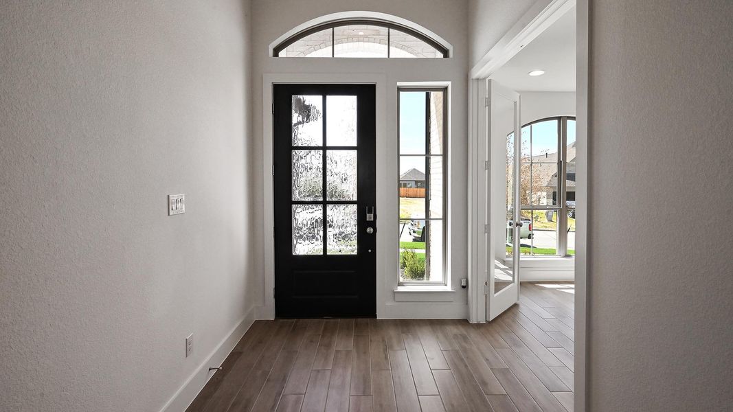 Foyer featuring a textured wall and dark wood-style flooring