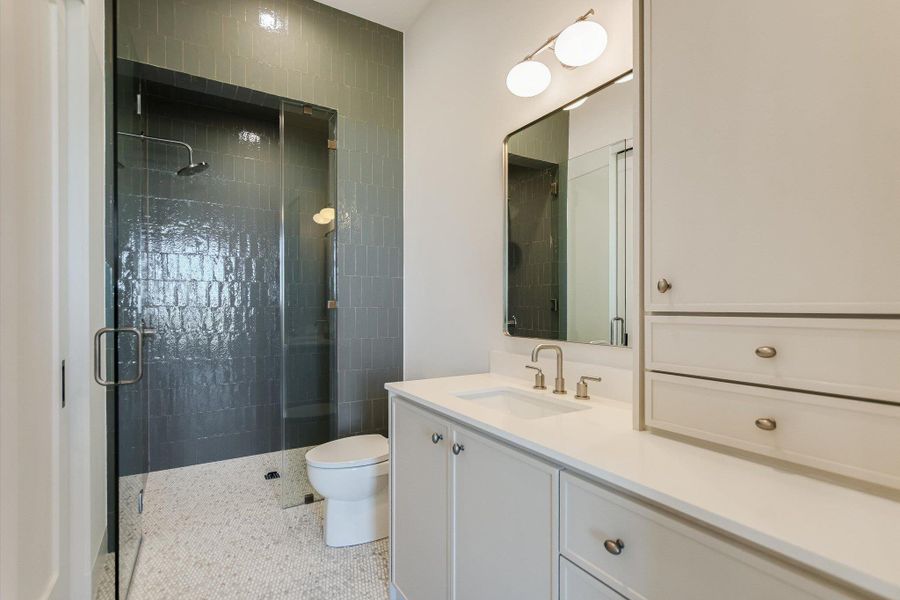 Bathroom featuring vanity, dark aggregate flooring, and a stall shower
