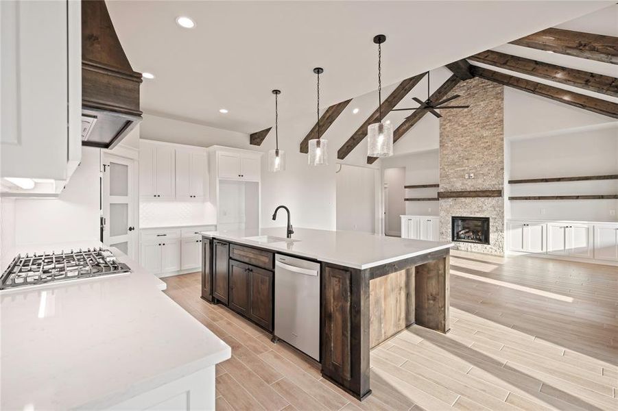 Kitchen with appliances with stainless steel finishes, a sink, ceiling fan, beamed ceiling, and white cabinetry Kitchen with appliances with stainless steel finishes, a sink, ceiling fan, beamed ceiling, and white cabinetry