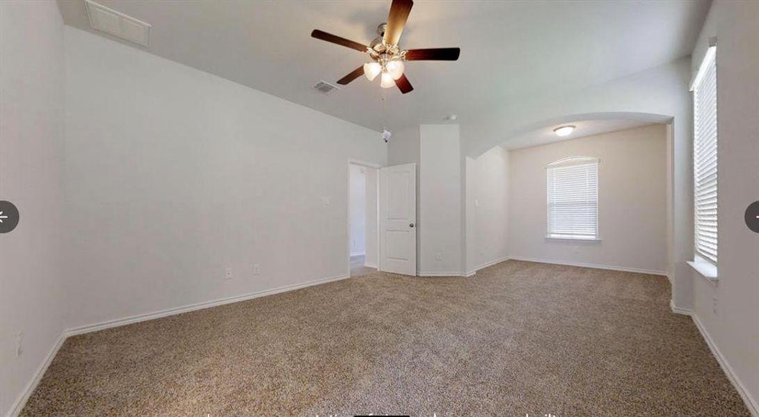 Spare room featuring arched walkways, a ceiling fan, carpet flooring, and baseboards