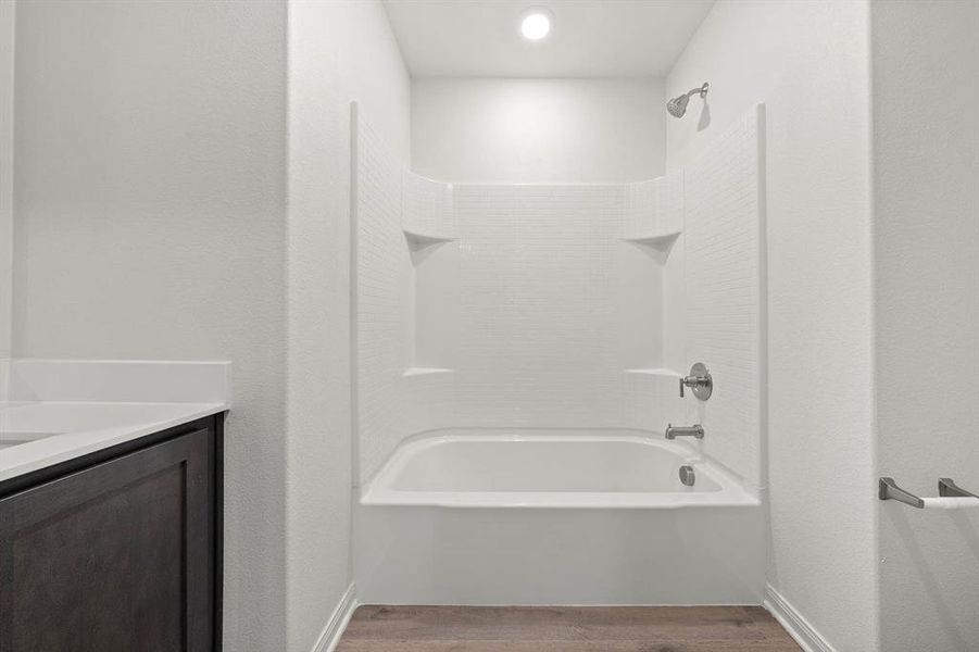 Bathroom featuring wood-style flooring, shower / washtub combination, and vanity