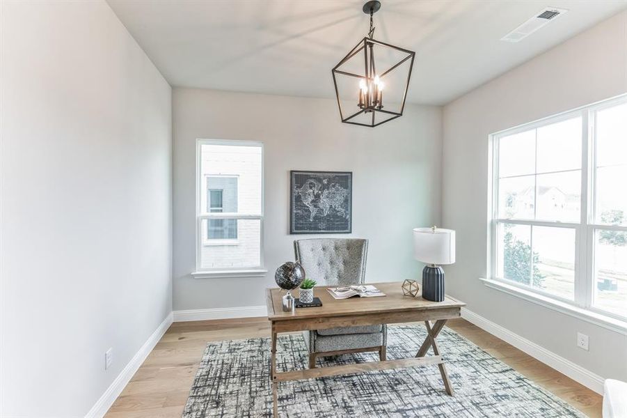 Office space featuring a notable chandelier and light hardwood / wood-style floors