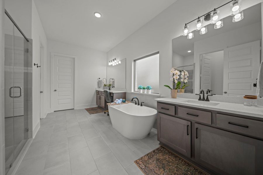 Spa-inspired primary bath with freestanding soaking tub, dual vanities, and walk-in shower. A calm and refreshing space. Spa-inspired primary bath with freestanding soaking tub, dual vanities, and walk-in shower. A calm and refreshing space.