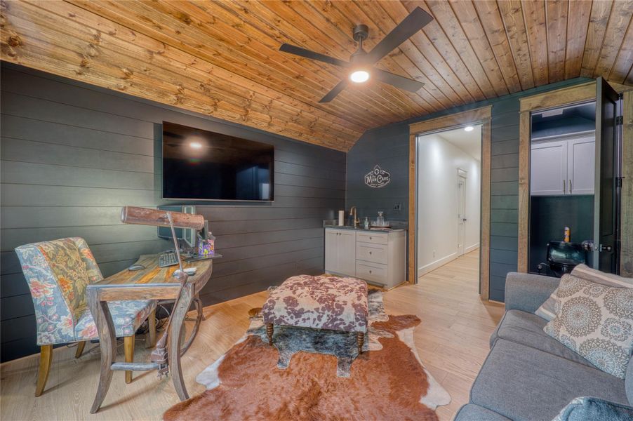 Accent wall paneling and wood-finish ceiling with a ceiling fan