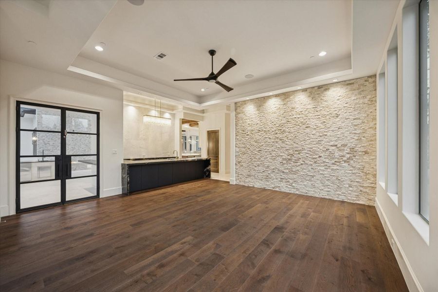Expansive game room with wet bar and adjacent powder bath, perfectly positioned beside the home theater for seamless entertaining. Expansive game room with wet bar and adjacent powder bath, perfectly positioned beside the home theater for seamless entertaining.