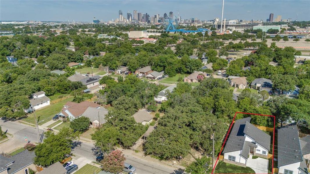 Aerial view of property and surrounding area with property boundaries highlighted and city skyline Aerial view of property and surrounding area with property boundaries highlighted and city skyline