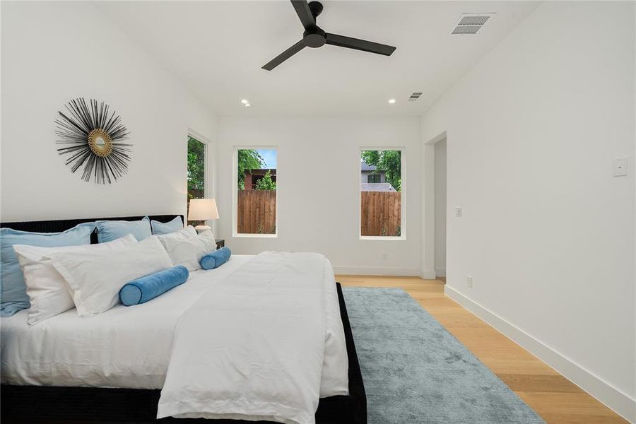 Spacious room featuring hardwood flooring, recessed lighting, and a ceiling fan