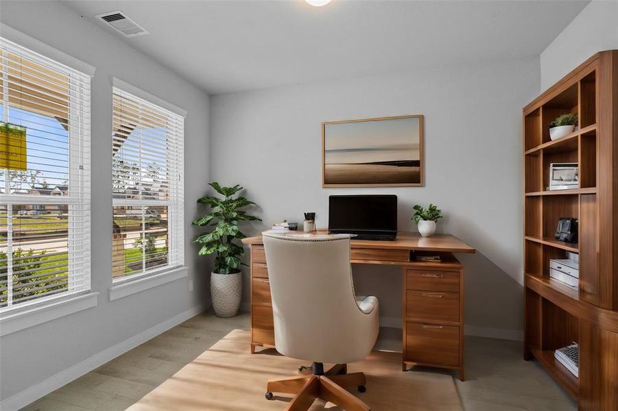 Quietly nestled in front of the home is the handsome home office. Featuring tile flooring, high ceilings, large windows with privacy blinds and custom paint.