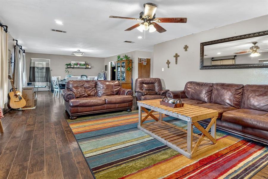 Living room featuring dark wood finished floors and a ceiling fan Living room featuring dark wood finished floors and a ceiling fan