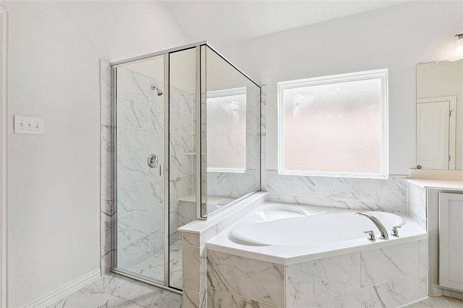 Bathroom with vanity, tile flooring, and shower with separate bathtub