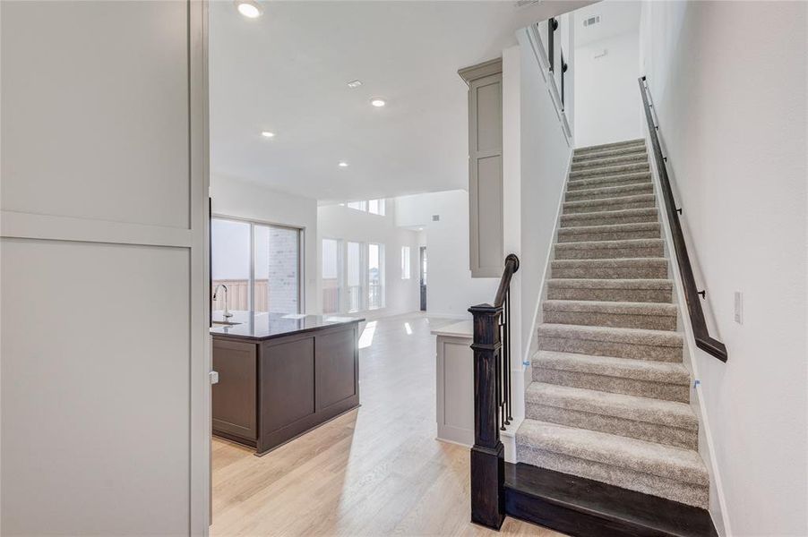 Staircase featuring hardwood / wood-style flooring and sink