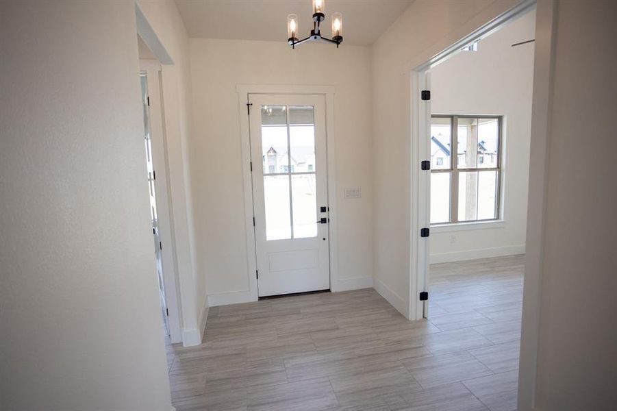 Entrance foyer with plenty of natural light, a chandelier, and light wood-type flooring Entrance foyer with plenty of natural light, a chandelier, and light wood-type flooring
