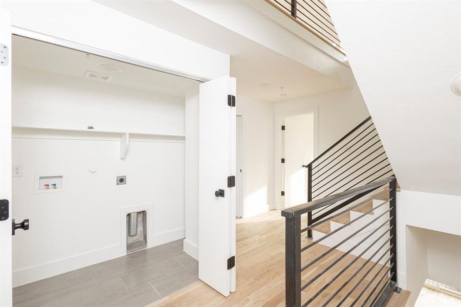 Washroom featuring hookup for a gas dryer, hookup for an electric dryer, laundry area, washer hookup, and wood finished floors