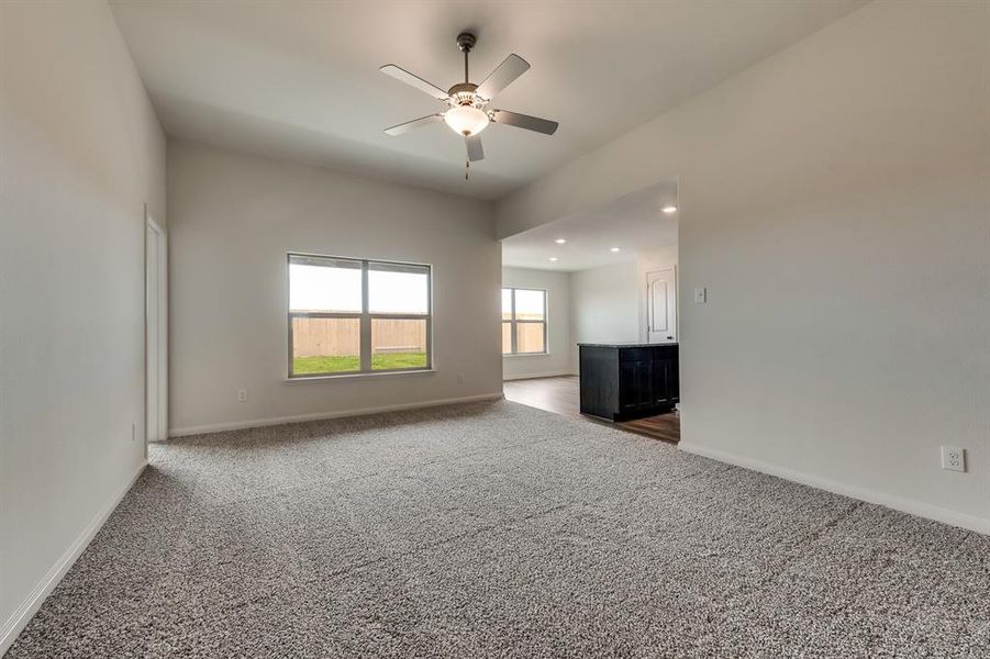 Spare room featuring dark colored carpet and ceiling fan