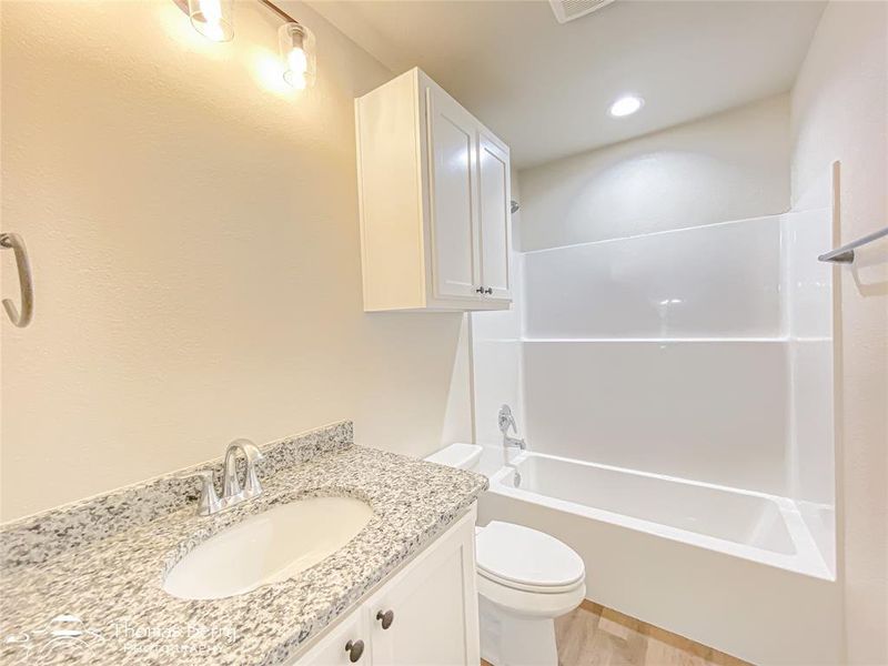 Bathroom with vanity, shower / tub combination, light wood-style floors, and recessed lighting Bathroom with vanity, shower / tub combination, light wood-style floors, and recessed lighting