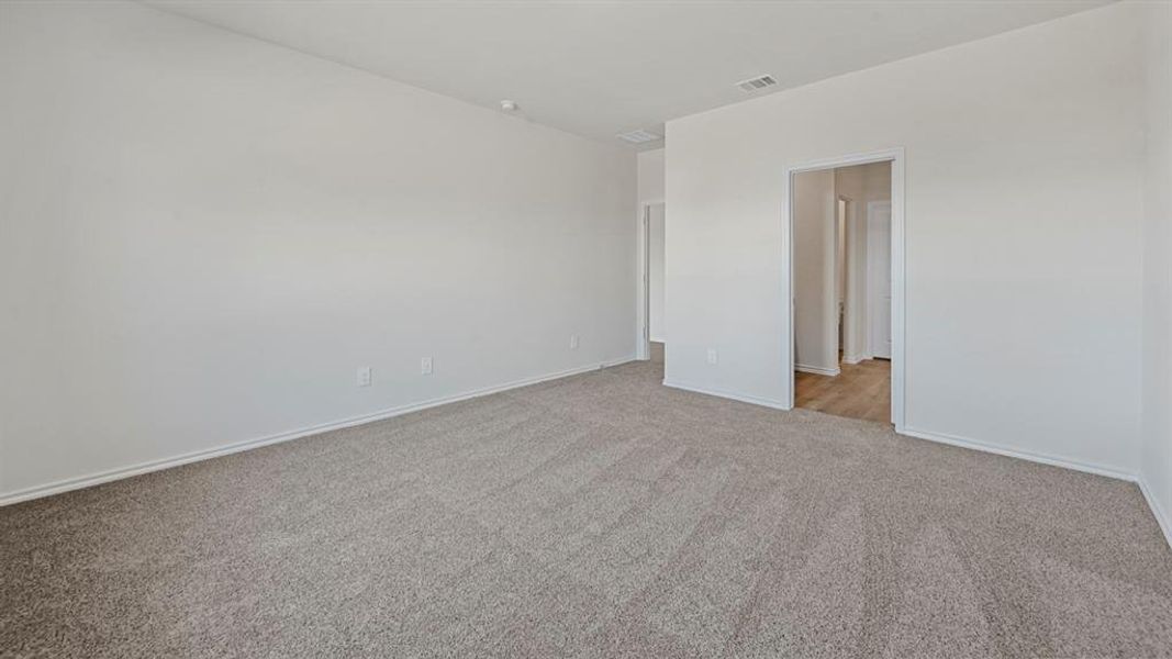Spare room featuring carpet flooring and baseboards