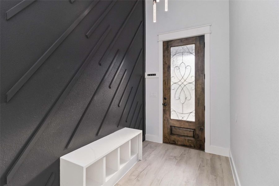 Mudroom featuring light wood finished floors and baseboards