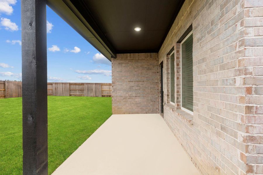 Covered back patio with brick exterior, ideal for relaxing evenings or weekend barbecues—schedule your private tour today!