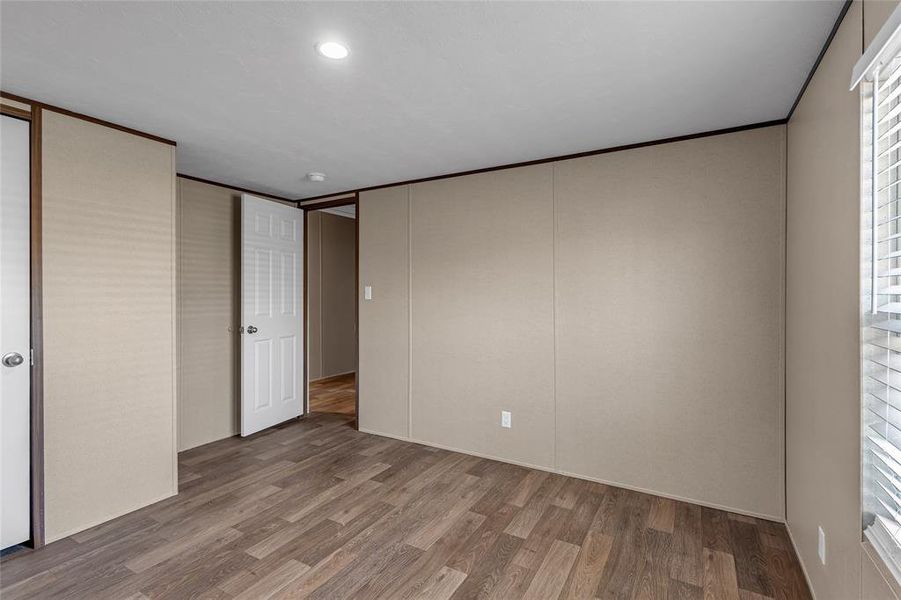 Unfurnished bedroom with crown molding and wood-type flooring