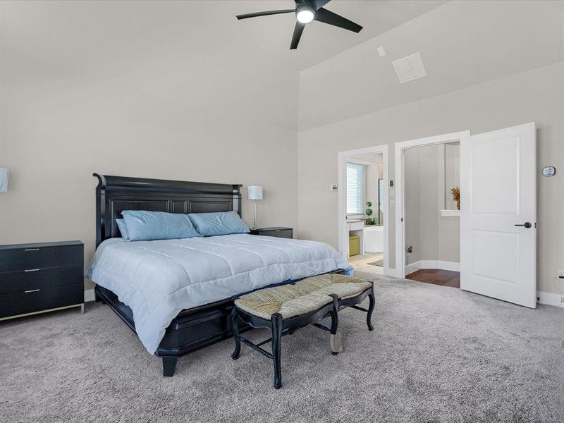Bedroom featuring connected bathroom, carpet, high vaulted ceiling, and ceiling fan Bedroom featuring connected bathroom, carpet, high vaulted ceiling, and ceiling fan
