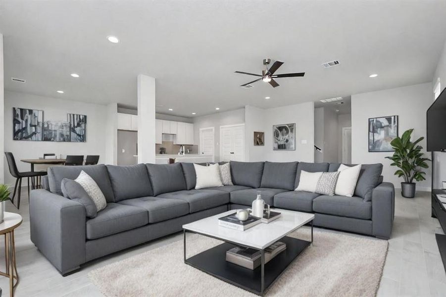 Family room flooded with natural light through the expansive windows.  The premium tile flooring adds a touch of luxury to the space, creating the perfect setting for relaxing moments and cherished gatherings with loved ones