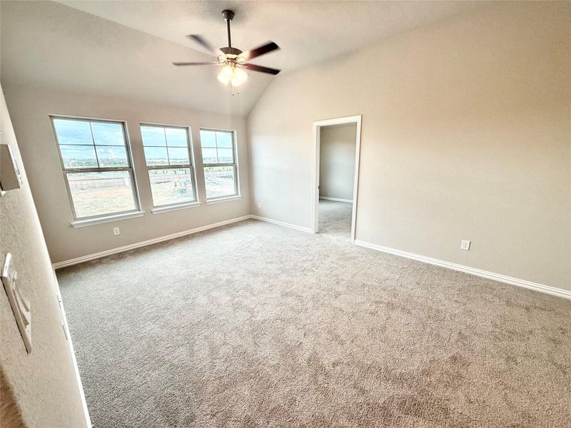 Unfurnished bedroom with lofted ceiling, carpet, and a ceiling fan Unfurnished bedroom with lofted ceiling, carpet, and a ceiling fan