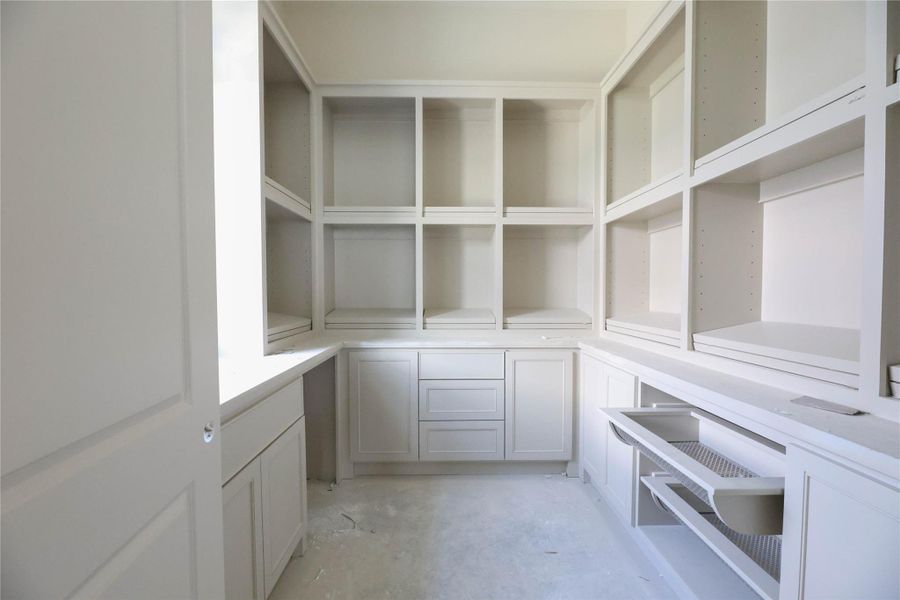Scullery/Butler's Pantry features custom site built storage space w/ dry wine rack, 2nd dishwasher and sink.